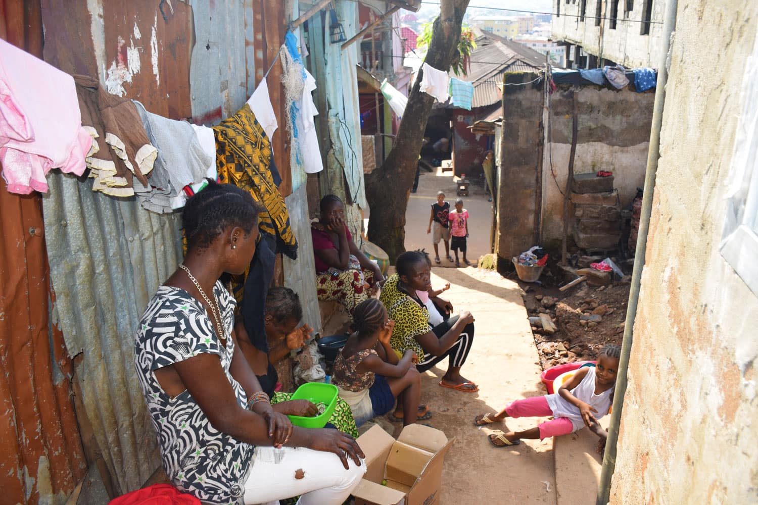 Mujeres y niños sentados en la calle - Proyecto Prevenir desde la Familia de Child Heroes
