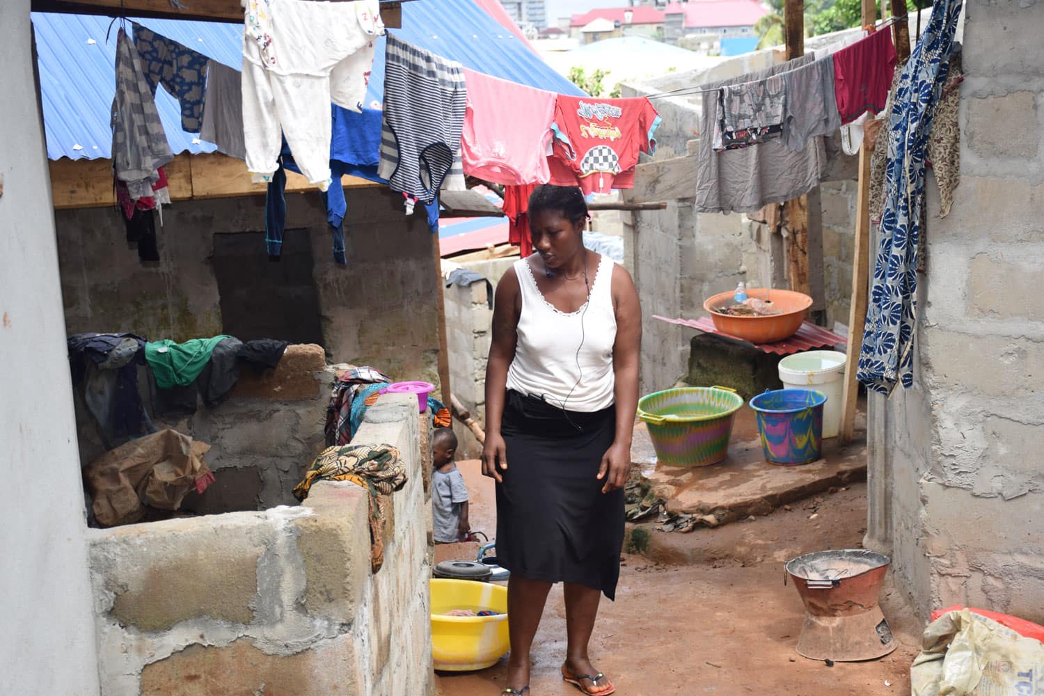 Mujer de pie entre ropa tendida - Proyecto Prevenir desde la Familia de Child Heroes